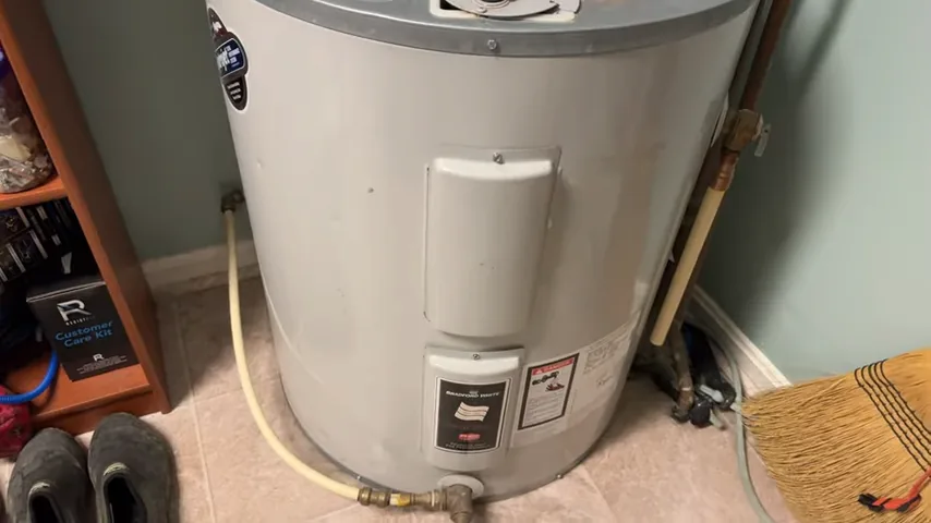 Electric tank water heater with front access covers and nearby pipework